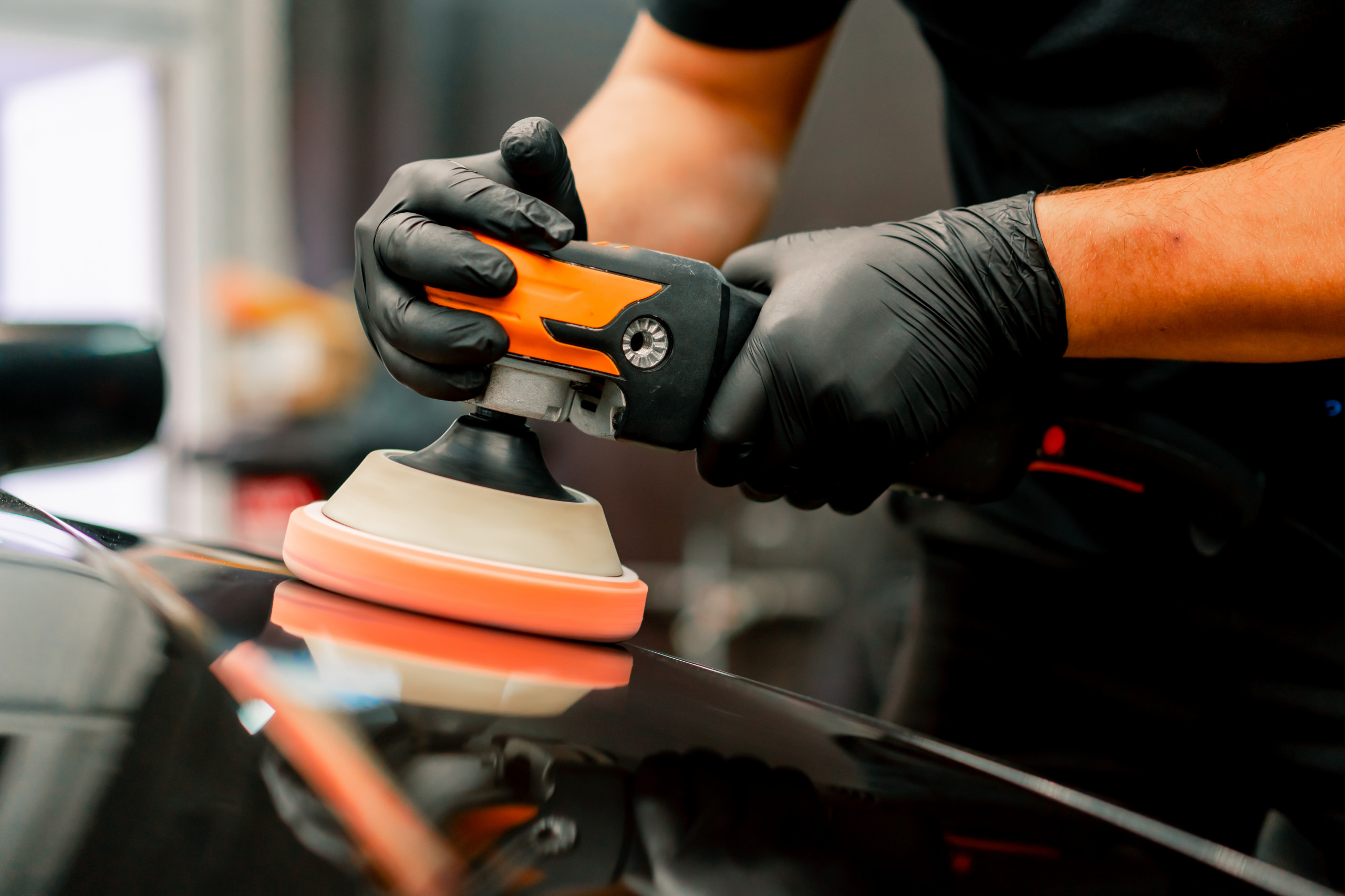 machine to polish the hood of a black luxury car